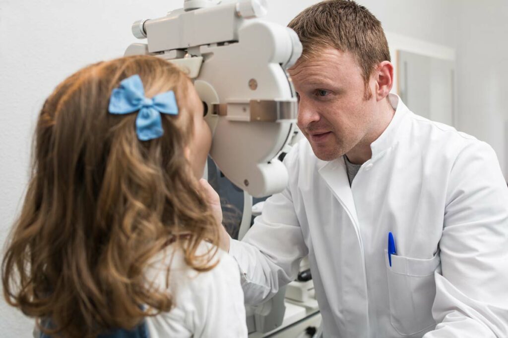 an optician testing a young girls eyes