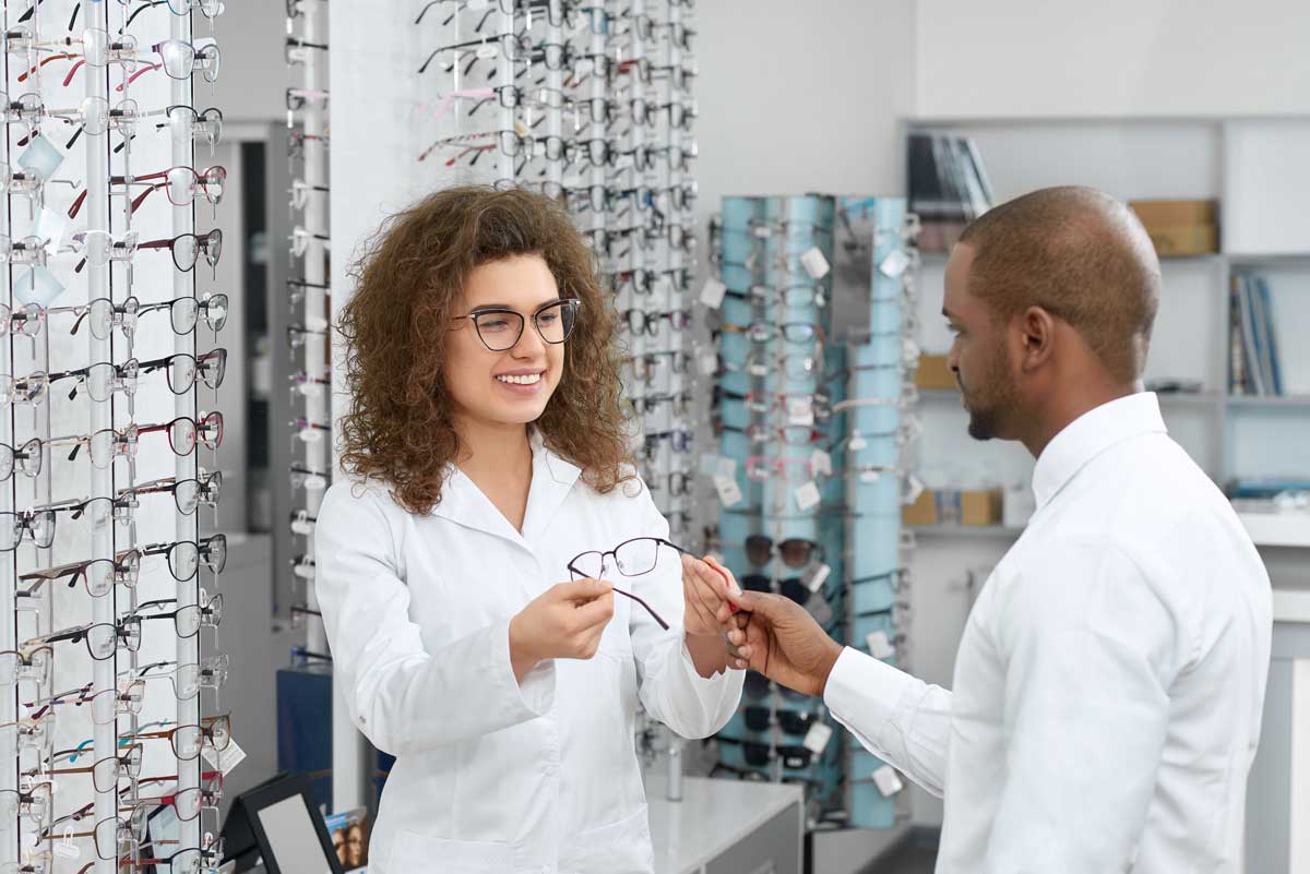 optician helping a customer choose his glasses