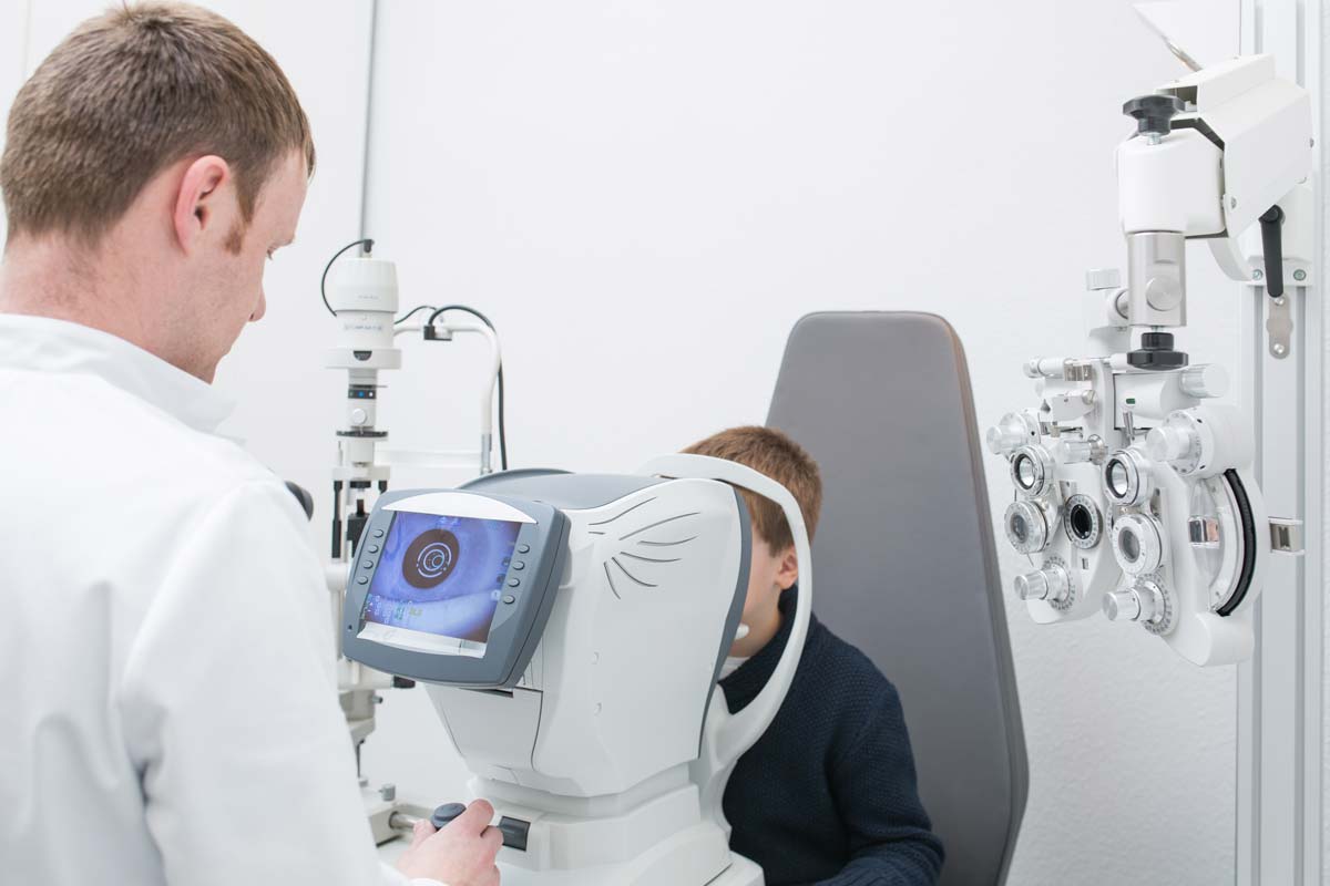 young boy having his eyes looked at by an optician